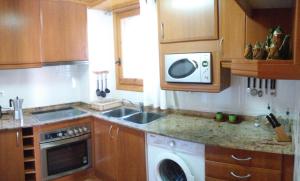 VilallerCasa Antonia的厨房配有洗衣机和微波炉。
