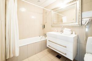 克里斯蒂安斯费尔德格瑞斯库伽米勒酒店的一间带水槽、浴缸和镜子的浴室