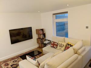 伦敦Modern 2 Bedroom Flat with private outdoor terrace的带沙发和平面电视的客厅