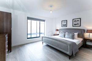 伦敦阿尔德盖特城市公寓的一间卧室设有一张床和一个大窗户