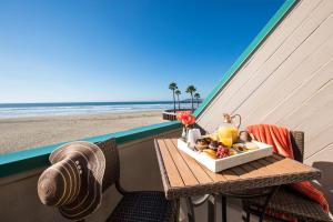 皮斯莫比奇海上冒险海滩酒店的俯瞰海滩的阳台的餐桌和食品托盘