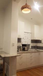 Low Head科克壳牌公寓的厨房配有白色橱柜和台面