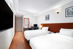 釜山雄狮酒店的酒店客房设有两张床和一台平面电视。