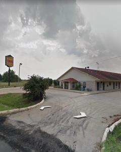 福雷斯特城Rest Inn Motel的一条空的路,在一座有白色箭头的建筑前
