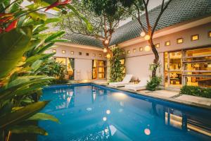 库塔巴厘岛洛卡尔旅舍的植物屋前的游泳池