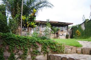 布琼布拉VAYA APARTMENTS Kiriri with Panoramic View的棕榈树和石墙的房子