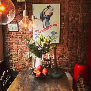 阿姆斯特丹The Lastage Inn - Bed & Breakfast的一张木桌,放着一碗水果和鲜花