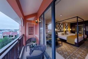 会安Allegro Hoi An . A Little Luxury Hotel & Spa的一间卧室设有一张床,阳台设有阳台。