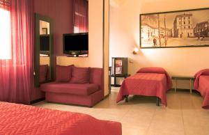 埃博利格拉齐亚埃博利酒店的酒店的客房 - 带一张床、椅子和电视
