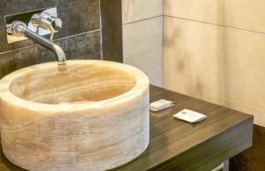 埃博利格拉齐亚埃博利酒店的浴室配有带水龙头的木制水槽。