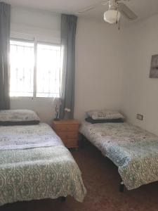 VistabellaCasa Verano的一间卧室设有两张床和窗户。