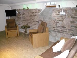 梅塞尼希Pension am Weinberg的客厅配有椅子和砖墙