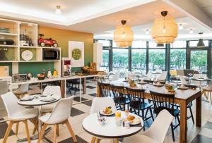旺夫巴黎旺夫爱达格公寓式酒店 - 波特德夏特林的餐厅设有桌椅和窗户。