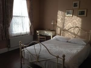 伦敦巴勒姆旅馆的一间卧室配有一张床、一张书桌和一个窗户。