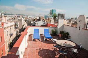 巴塞罗那Barceloneta Suites Apartments Beach的阳台配有2把蓝色椅子和桌子