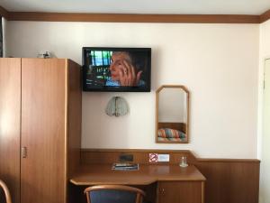 柏林柏林万里酒店的一间墙上配有电视和书桌的房间