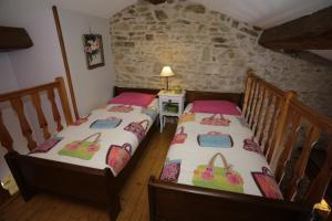 Soucieu-en-JarrestCarpe Diem的石墙客房内的两张单人床
