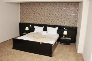 苏恰瓦帝国酒店的一间卧室配有一张带2个床头柜的大床