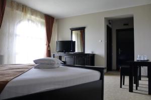 苏恰瓦帝国酒店的酒店客房,配有床和电视