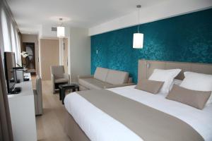 里尔贝斯维斯特高级酒店的卧室配有一张白色大床和蓝色的墙壁
