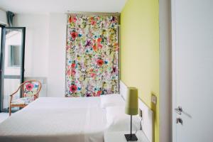 萨尔索马焦雷泰尔梅精英酒店的卧室配有白色的床和花卉窗帘