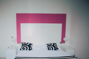 萨尔索马焦雷泰尔梅精英酒店的卧室配有白色床和紫色床头板