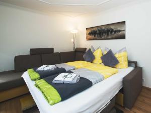 万丹斯Ferienwohnung - Bergblick - Vandans的一张大床,房间配有黄色和蓝色枕头