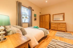 普里茅斯Elm Lodge的一间卧室配有一张床、一个梳妆台和一扇窗户。