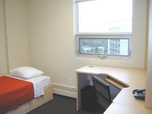 埃德蒙顿阿尔伯塔大学住宿旅馆的客房设有床、书桌和窗户。