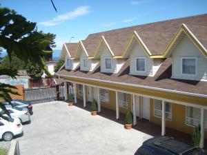 蒙特港Apart Hotel en Puerto Montt的黄色的房子,屋顶有停车场