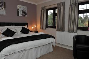 Hillington林登住宿加早餐旅馆的一间卧室设有一张大床和两个窗户。