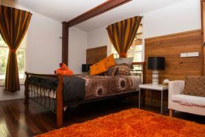 彭伯顿Mudstone Spa Retreat的一间卧室配有一张大床和一把椅子