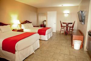 普莱西德湖格拉西湖套房酒店 的酒店客房设有两张床和一张桌子。