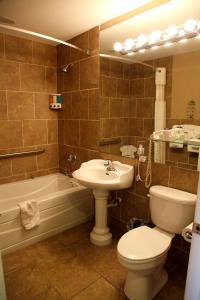 普莱西德湖格拉西湖套房酒店 的浴室配有盥洗盆、卫生间和浴缸。