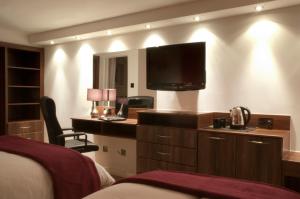翰索哈维里酒店的酒店客房设有一张床和墙上的电视