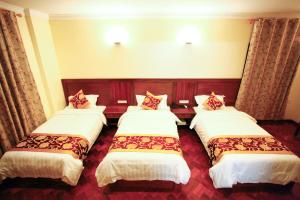 曼德勒特宏酒店的一间酒店客房,房间内设有三张床