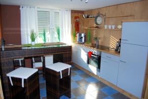 翁纳Apartment Unna-Massen的厨房配有白色家电和带凳子的台面