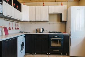 伊热夫斯克Five Stars Style的厨房配有黑炉和冰箱。