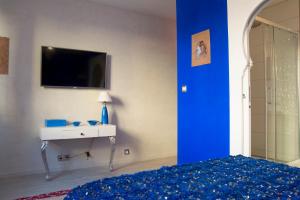 图尔Riad SPA "Les Portes de l'Orient" TOURS的一间卧室配有一张床、一个水槽和一台电视