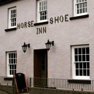 克里克豪厄尔The Horseshoe Inn的一座白色的建筑,上面写着马鞋旅馆