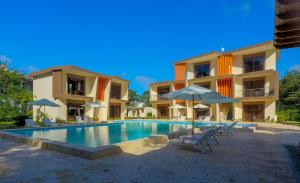 苏莎亚加勒比钻石精品酒店的大楼前的游泳池配有椅子和遮阳伞