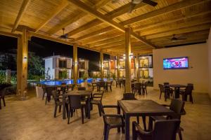 苏莎亚加勒比钻石精品酒店的餐厅设有桌椅和平面电视。