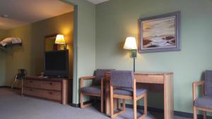 KewauneeHarbor Lights Lodge的一间设有两把椅子、一张桌子和一台电视的房间