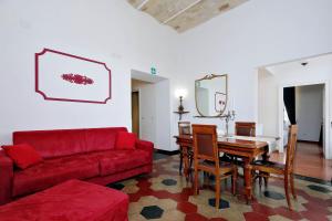 罗马斗兽场甜蜜公寓的客厅配有红色的沙发和桌子