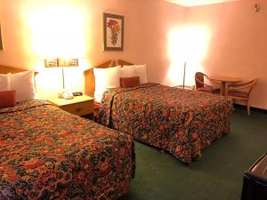 罗斯维尔罗斯维尔基酒店的酒店客房设有两张床和一张桌子。