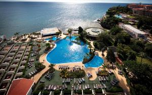 丰沙尔马德拉岛海洋佩斯塔纳酒店的享有毗邻大海的游泳池的顶部景致