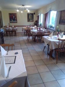 乌尔姆金索恩旅馆的餐厅配有桌椅和白色的桌布