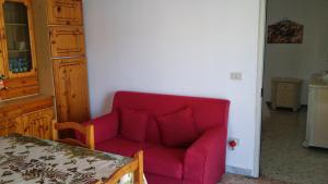 马蒂纳塔attico centro mattinata的客厅配有红色的沙发和桌子