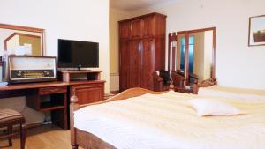 OrašjeHotel Derby Orašje的一间卧室配有一张床和一张书桌及电视