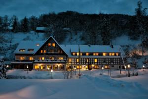 施马伦贝格汤姆斯祖尔缪旅馆的一座大建筑物,在晚上下雪